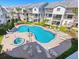 Aerial view of a community pool area featuring a large pool, hot tub, lounge chairs, and well-manicured landscaping at 125 Shoals Cir, North Redington Beach, FL 33708