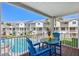 Inviting balcony with seating, offering a pleasant view of the community pool and nearby buildings at 125 Shoals Cir, North Redington Beach, FL 33708