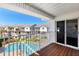 Balcony overlooking a well-maintained pool area, surrounded by lush landscaping and neighboring buildings at 125 Shoals Cir, North Redington Beach, FL 33708