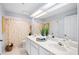 Bright bathroom with a double vanity and a shower with a decorative curtain at 125 Shoals Cir, North Redington Beach, FL 33708