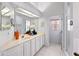 Bright, all-white bathroom featuring a large vanity with a sink, ample counter space, and modern fixtures at 125 Shoals Cir, North Redington Beach, FL 33708