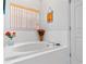 Relaxing bathtub area featuring white tile, a decorative window with blinds, and a soothing ambiance at 125 Shoals Cir, North Redington Beach, FL 33708