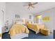 Comfortable bedroom featuring two beds, soft yellow decor, and a ceiling fan at 125 Shoals Cir, North Redington Beach, FL 33708