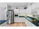 Bright kitchen with white cabinets, dark countertops, and stainless steel appliances at 125 Shoals Cir, North Redington Beach, FL 33708