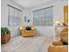 Bright living room featuring wood floors, large windows with wood trim, and comfortable yellow chair at 125 Shoals Cir, North Redington Beach, FL 33708