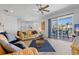 Cozy living room with a ceiling fan, a sliding glass door to the balcony, and coastal decor at 125 Shoals Cir, North Redington Beach, FL 33708