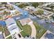 Aerial view of a waterfront property with a paved driveway and boat dock on a sunny day at 13437 Lisa Dr, Hudson, FL 34667