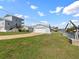 Waterfront home with a two-car garage, boat lift, and paved driveway on a sunny day at 13437 Lisa Dr, Hudson, FL 34667