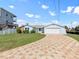 Charming single-story waterfront home with a paver driveway, attached two-car garage, and lush lawn at 13437 Lisa Dr, Hudson, FL 34667