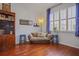 Cozy living room with hardwood floors, a futon, and natural light from the large window at 1354 Forestedge Blvd, Oldsmar, FL 34677