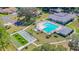 An aerial view features the community pool, shuffleboard court, and clubhouse nestled among mature trees and landscaping at 13542 Norman Cir, Hudson, FL 34669