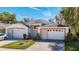 Well-maintained single-story home with a three-car garage and colorful trim stands in an inviting residential setting at 13542 Norman Cir, Hudson, FL 34669