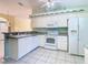 Well-lit kitchen features white appliances and cabinets, with a view into the dining area at 13542 Norman Cir, Hudson, FL 34669