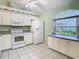Bright kitchen features white appliances, cabinetry, and a charming window, offering ample space at 13542 Norman Cir, Hudson, FL 34669