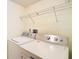 Functional laundry area with a washing machine, dryer, and storage shelf, enhancing convenience at 13542 Norman Cir, Hudson, FL 34669