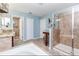 Bright bathroom featuring a glass-enclosed shower, soaking tub, vanity with stone countertop, and neutral tile flooring at 13856 Crest Lake Dr, Hudson, FL 34669