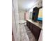 Well-lit bathroom with double sinks, granite countertop, shower-tub combo, tile floors, and a framed mirror at 13856 Crest Lake Dr, Hudson, FL 34669