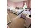 Charming pink bedroom with multiple beds, soft carpet, and natural light at 13856 Crest Lake Dr, Hudson, FL 34669