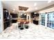 Open kitchen features an island, black cabinets, and opens to the gym at 13856 Crest Lake Dr, Hudson, FL 34669