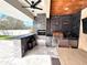 Outdoor kitchen featuring marble tiling, stainless steel appliances, and bar seating at 13856 Crest Lake Dr, Hudson, FL 34669