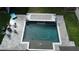 Aerial view of a custom pool with a waterfall feature, surrounded by a stone patio and outdoor seating at 13856 Crest Lake Dr, Hudson, FL 34669