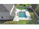 Aerial view of a backyard showcasing a pool, patio area, outdoor seating, and manicured lawn at 13856 Crest Lake Dr, Hudson, FL 34669