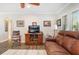 Cozy living room featuring hardwood floors, a leather sofa, and plenty of natural light at 13920 Pinecrest Dr, Largo, FL 33774