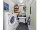 Well-equipped laundry room featuring modern appliances, a work table, and storage shelves at 1400 1St W Ave # G1, Bradenton, FL 34205