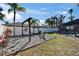 A backyard with a hammock seating area, palm trees, and screened-in pool offers outdoor enjoyment at 1425 Monte Lake Dr, Valrico, FL 33596
