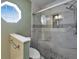 Updated bathroom showcasing a glass-enclosed shower with marbled tile and a unique octagon window at 1425 Monte Lake Dr, Valrico, FL 33596