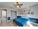 Comfortable bedroom featuring a blue accent wall, ceiling fan, and colorful superhero artwork at 1425 Monte Lake Dr, Valrico, FL 33596
