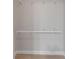 Empty closet interior with white wooden pole and shelf fixtures against gray walls and wood flooring at 1425 Monte Lake Dr, Valrico, FL 33596