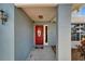 Charming home entrance with a vibrant red door, textured blue walls, and a welcoming, covered porch at 1425 Monte Lake Dr, Valrico, FL 33596