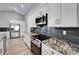 Modern kitchen with stainless steel appliances, dark backsplash, granite counters, and white cabinets at 1425 Monte Lake Dr, Valrico, FL 33596