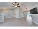 Open living room features light wood floors, modern ceiling fan, and sliding glass doors to the pool area at 1425 Monte Lake Dr, Valrico, FL 33596