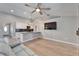 Open concept living room/kitchen with ceiling fan, hardwood floors, tv and modern lighting at 1425 Monte Lake Dr, Valrico, FL 33596