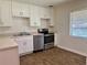 Updated kitchen featuring stainless steel appliances, white cabinets, and a modern sink at 1475 S Jefferson Ave, Clearwater, FL 33756