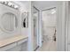 Bathroom features a vanity, makeup table, round mirror, and glass enclosed shower at 19029 Us Highway 19 N # 17A, Clearwater, FL 33764