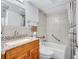 Bathroom featuring tiled shower and tub, wood vanity with granite top, sink, toilet at 19029 Us Highway 19 N # 17A, Clearwater, FL 33764