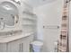 Bathroom featuring vanity, round mirror, toilet, shelves, and shower at 19029 Us Highway 19 N # 17A, Clearwater, FL 33764