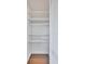 Walk-in closet featuring white shelving and laminate wood flooring with a louvered door at 19029 Us Highway 19 N # 17A, Clearwater, FL 33764