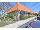 Charming condo exterior featuring lush landscaping, a red tile roof and sidewalk at 19029 Us Highway 19 N # 17A, Clearwater, FL 33764