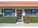 Inviting front entrance with a red tiled roof, lush green landscaping, and a modern glass door at 19029 Us Highway 19 N # 17A, Clearwater, FL 33764