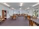 Large, well-lit game room with multiple tables and chairs for entertainment and community engagement at 19029 Us Highway 19 N # 17A, Clearwater, FL 33764