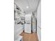 Efficient laundry space featuring a stacked washer/dryer, shelving, and wood-look flooring at 19029 Us Highway 19 N # 17A, Clearwater, FL 33764