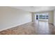 Open floorplan living room with large window overlooking the lake featuring tile flooring and neutral paint at 19029 Us Highway 19 N # 17A, Clearwater, FL 33764