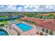 Expansive community pool with lounge chairs surrounded by mature landscaping, tennis courts and multi-story residences at 19029 Us Highway 19 N # 17A, Clearwater, FL 33764