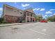 Apartment building with brick facade, balconies, and parking spots on a sunny day at 200 Country Club Dr # 1001, Largo, FL 33771