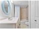 A classic bathroom features a vanity sink, blue framed oval mirror, and shower-tub combination at 2002 Blue Hawk Ct # 1724, Clearwater, FL 33762