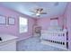 Pink bedroom with crib, white furnishings, and neutral carpet at 22167 Tucana Way, Land O Lakes, FL 34637